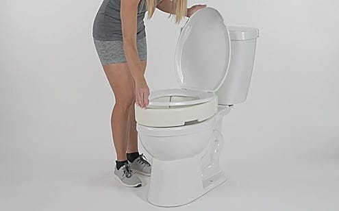 woman adjusting toilet seat riser