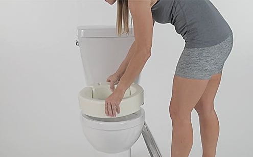 woman installing the toilet seat riser